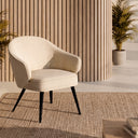 Butaca MACAO, en beige, ante una pared de listones de madera con alfombra de yute