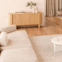 Aparador SIDNEY de 160 cm con 3 puertas, en un salón con sofá claro y suelo de madera