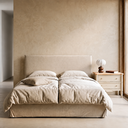 Cama canapé abatible tapizada en beige, en un dormitorio