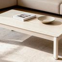 Mesa de centro ROLAND en travertino, delante de un sofá claro