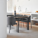 Silla tapizada MOGI con patas negras, en gris oscuro, en una cocina abierta – Teulat