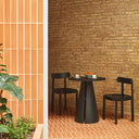 Silla NARA en negro, junto a una mesa redonda – Teulat