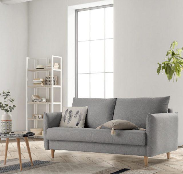 Sala de estar minimalista con sofá gris, mesa de centro y estantería. Decoración elegante.